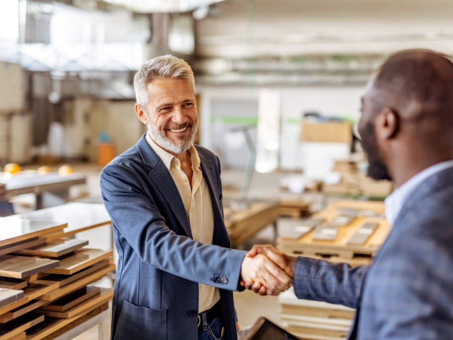 Two financial advisors shake hands in a public place, illustrating that Sovereign Advisor Solutions helps fiduciary advisors go independent the way they want to work